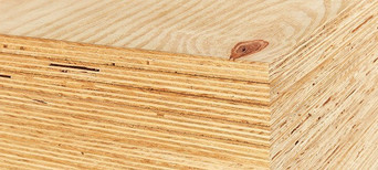 Gestapelte Bausperrholzplatten mit sichtbarer Schichtenverleimung und natürlicher Holzmaserung.